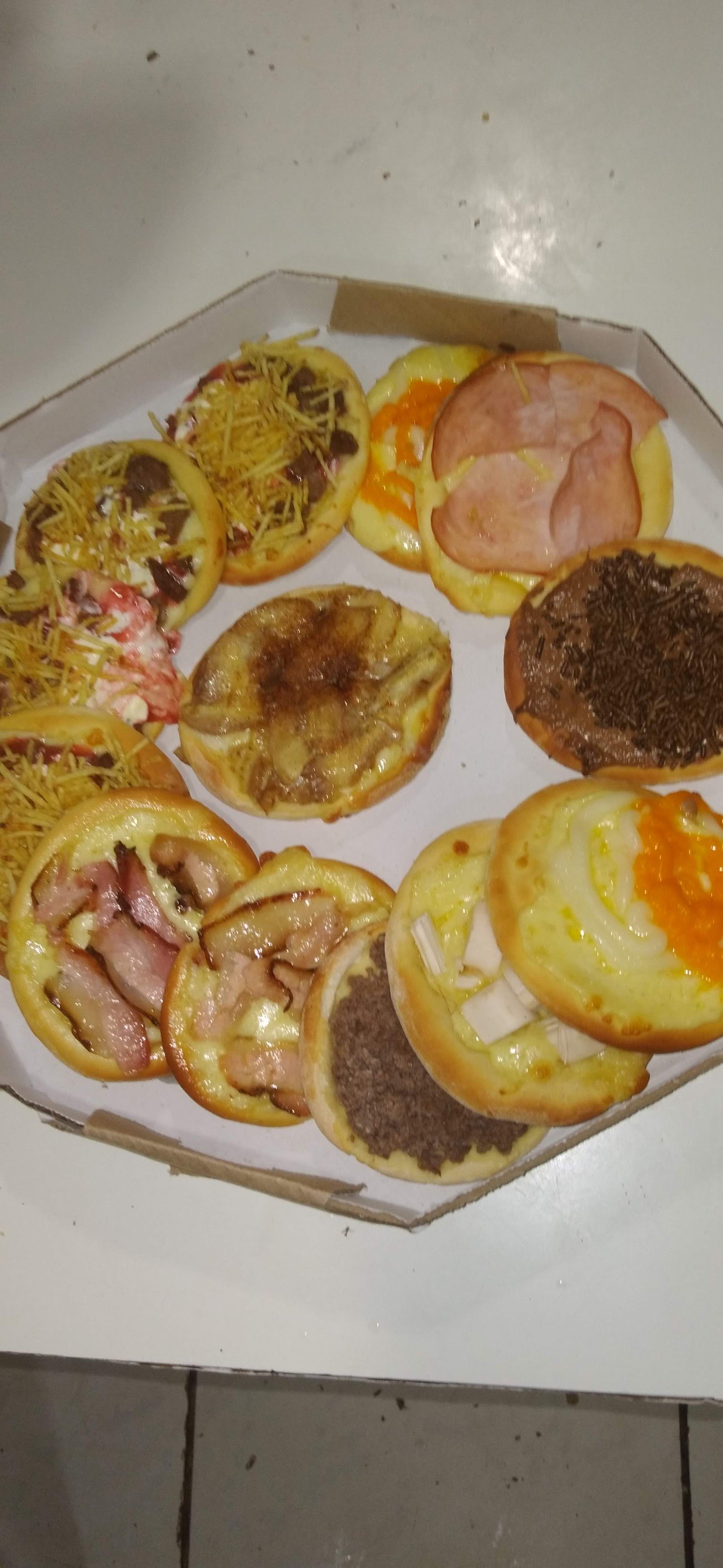 Caixa com mini pizzas variadas de calabresa, frango, bacon e chocolate